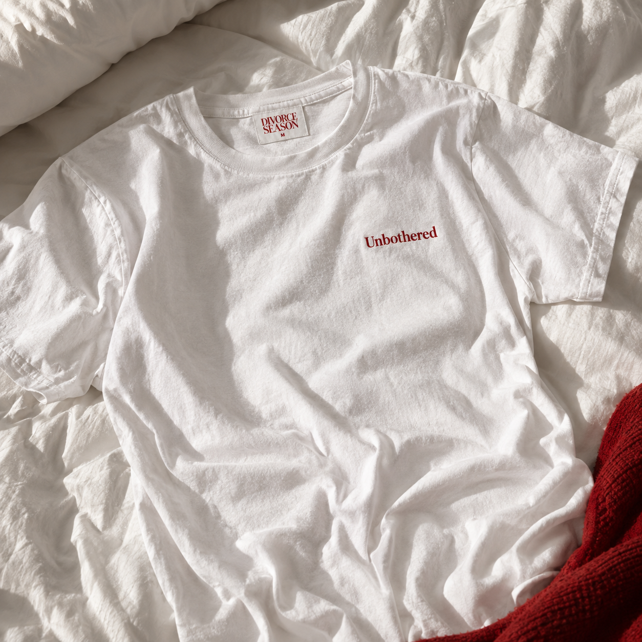 White Divorce Season Unbothered t-shirt on a bed